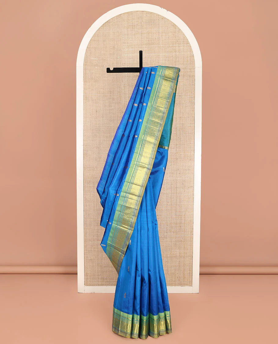 Blue Kanchipuram Silk Saree, Spotlighted with Zari Buttas on Its Body, Complemented by Contrast One-Sided Border of Panner Sombu, Banaras, Muthu, and Jaal Designs, Pallu Features Zari Designs, and Comes Without a Blouse
