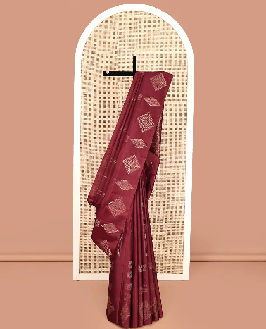 Borderless Maroon Mayuri Soft Silk Saree, Adorned with Buttas All Over Its Body, a Self-Pallu of Geometric Patterns, and Paired with a Matching Blouse
