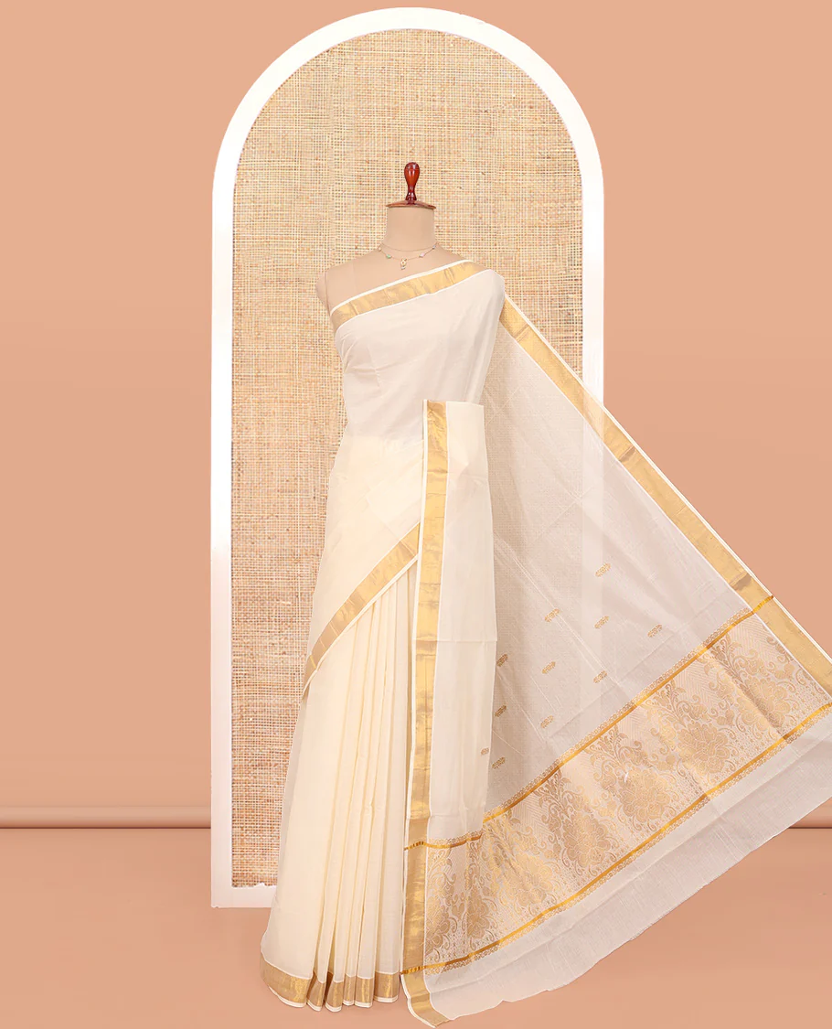 Cream Kerala Cotton Saree, Woven with Zari Buttas All Over Its Body, a Zari Bavanji Border, Pallu of Zari Designs, and Paired with a Matching Blouse