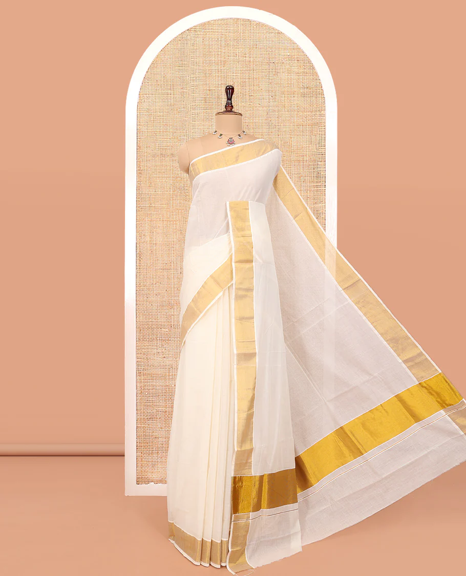 Cream Plain Kerala Cotton Saree, a Subtle Bavanji Border, Gleaming Zari Pallu, and Is Paired with a Matching Blouse