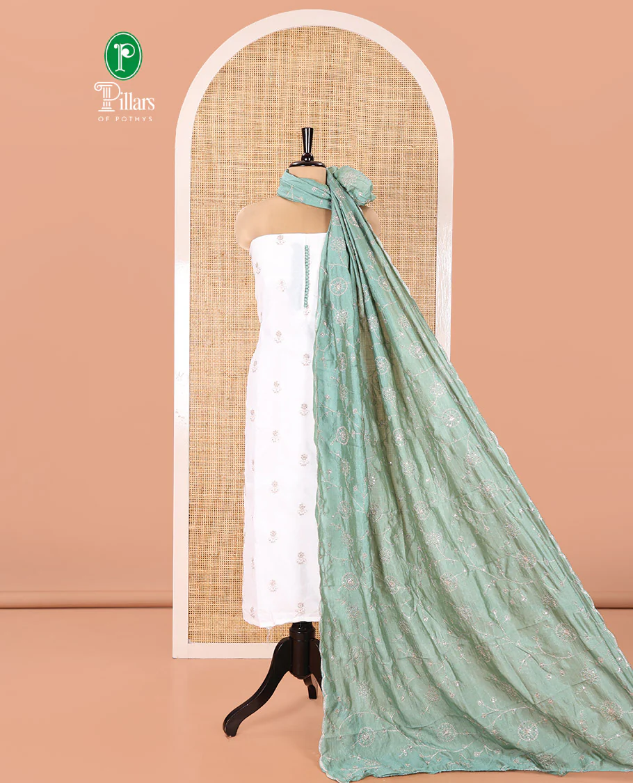 Cream with Green Vichitra Silk Material Chudidar Set, Elevated with Gold Zari Buttas On Its Top, a Plain Santoon Bottom, and Comes with a Floral Vine Sequins Embroidered Dupatta