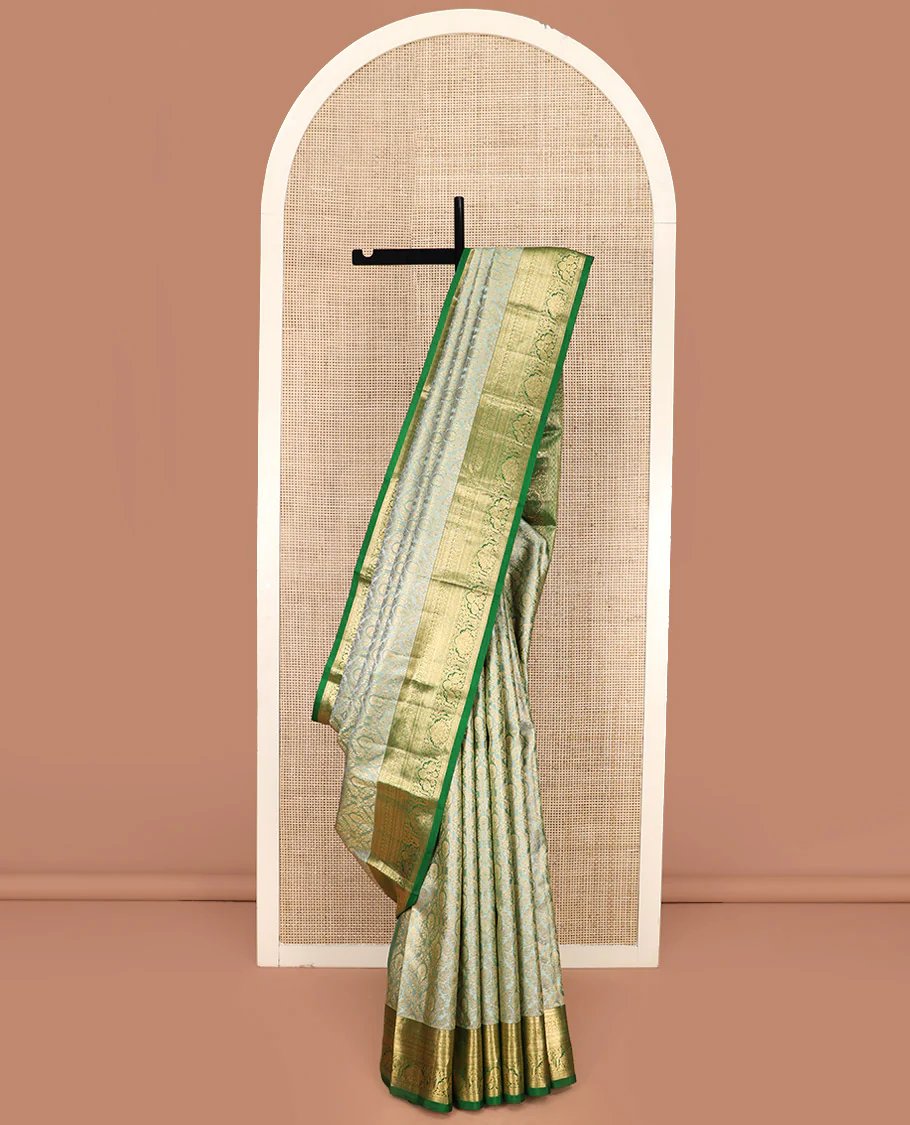 Green Kanchipuram Silk Saree Embellished with Jacquard Design, Highlighted by a Contrast Border of Thilakam, Muthu, Rekku, Manga, Chakram, and Floral Designs, Majestically Woven Pallu Steeped with Chakram Designs, and Paired with a Matching Blouse