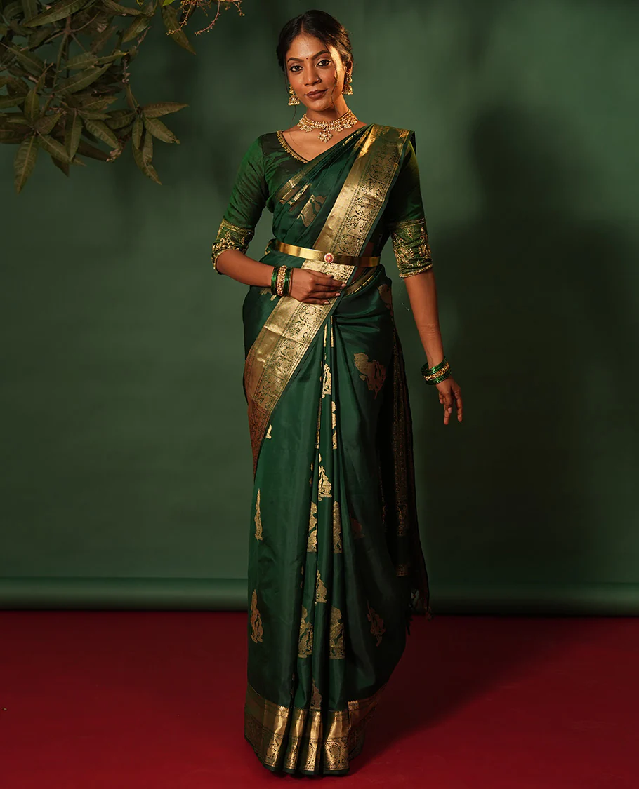 Green singam and yaanai zari buttas woven Vasundhara silk saree, zari border of mayil kann, rudraksham, muthu, mayil, and yaali designs, and intricate pallu