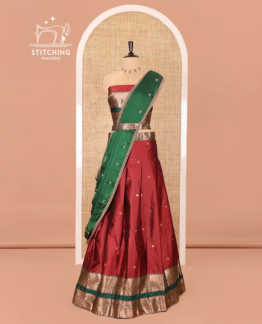 Maroon and Green Semi-Banarasi Half-Saree Featuring Zari Buttas Skirt, Complemented by Contrast Rettai Pettu, Traditional Border of Floral Creeper Designs, Paired with a Matching Blouse, and a Satin Georgette Embroidered Scallop Dhavani