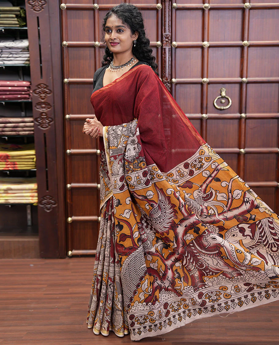 Maroon Kota Cotton Saree, Artfully Decked Up with Kalamkari-Style Human Figurines Printed on the Body, Subtle Piping Border, Pallu Pictures Kalamkari-Style Flora-Fauna Motifs, and Paired with a Contrast-Printed Blouse - Image 4