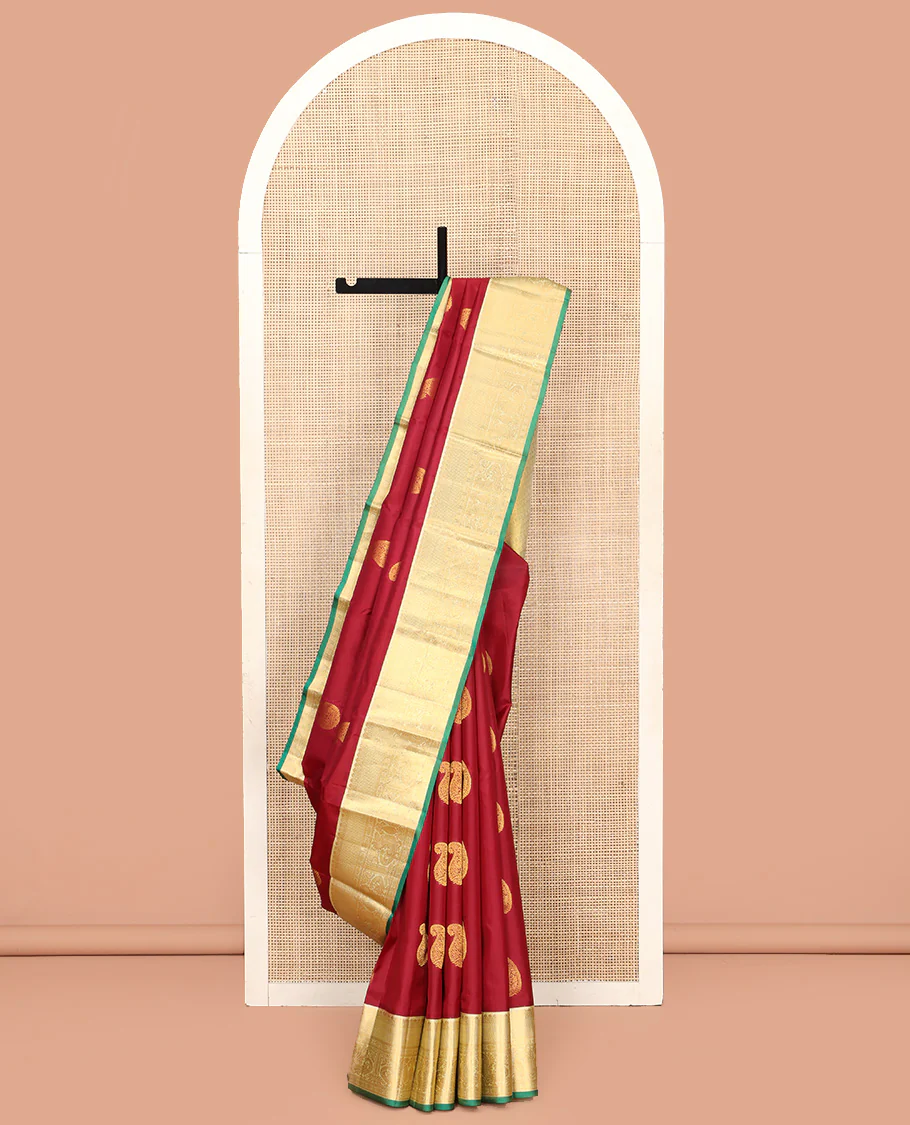 Maroon Vasundhara Silk Saree, Adorned with Arumbu Manga Buttas All Over Its Body, Complemented by Contrast Border of Thilakam Mokku, Mayil and Mayil Kann Designs, Grand Pallu and Paired with a Contrast Blouse