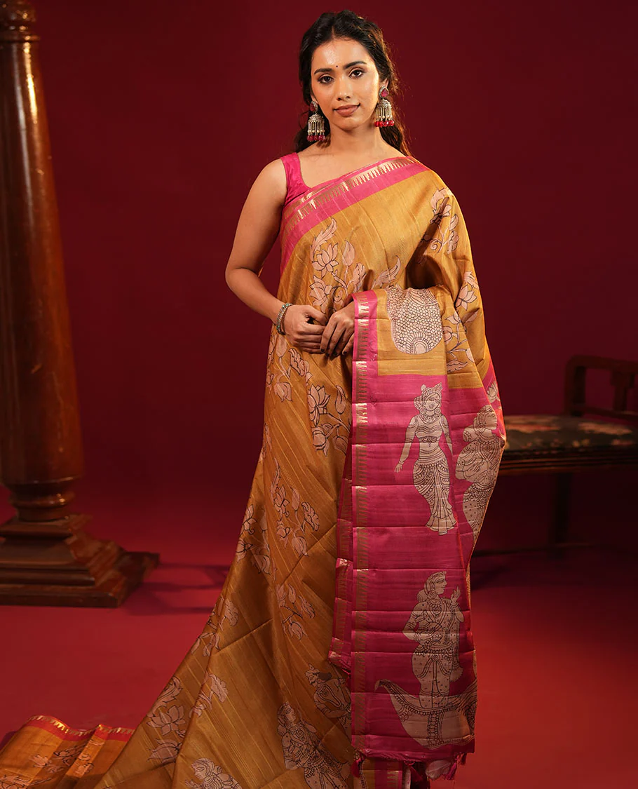 Mustard Semi-Tussar Silk Saree, Elegantly Detailed with Kalamkari-Style Human Motifs Printed on Its Body, Complemented by a Contrast Temple Zari Border, Creatively Kalamkari Printed Pallu, and Paired with a Contrast Blouse