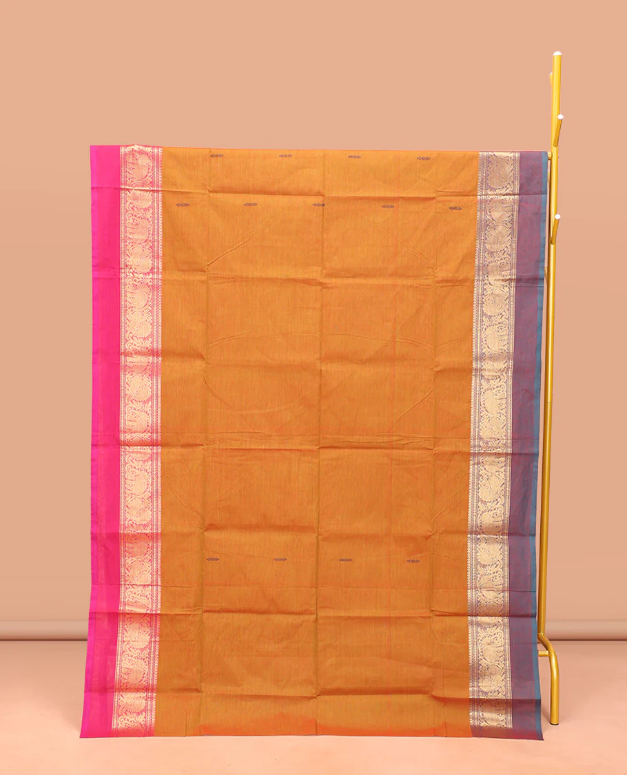 Orange Chettinad Cotton Saree, Finely Crafted with Buttas All Over Its Body, Complemented by a Contrast Ganga-Jamuna Kal Eragina Border of Kodi Peacock and Elephant Designs, Pallu of Buttas and Stripes, and Paired with a Matching Blouse