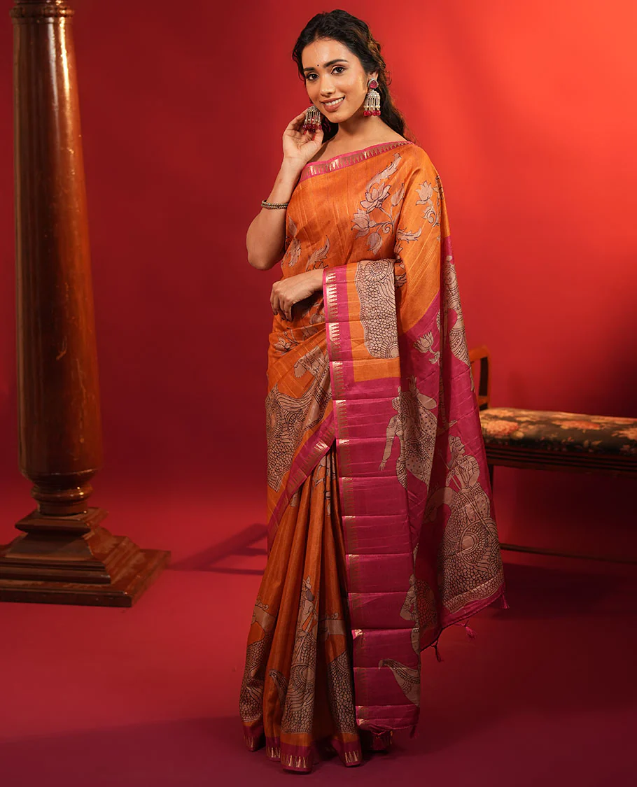 Orange Semi-Tussar Silk Saree, Artfully Detailed with Kalamkari-Style Human Motifs Printed on Its Body, Complemented by a Contrast Temple Zari Border, Creatively Kalamkari Printed Pallu, and Paired with a Contrast Blouse