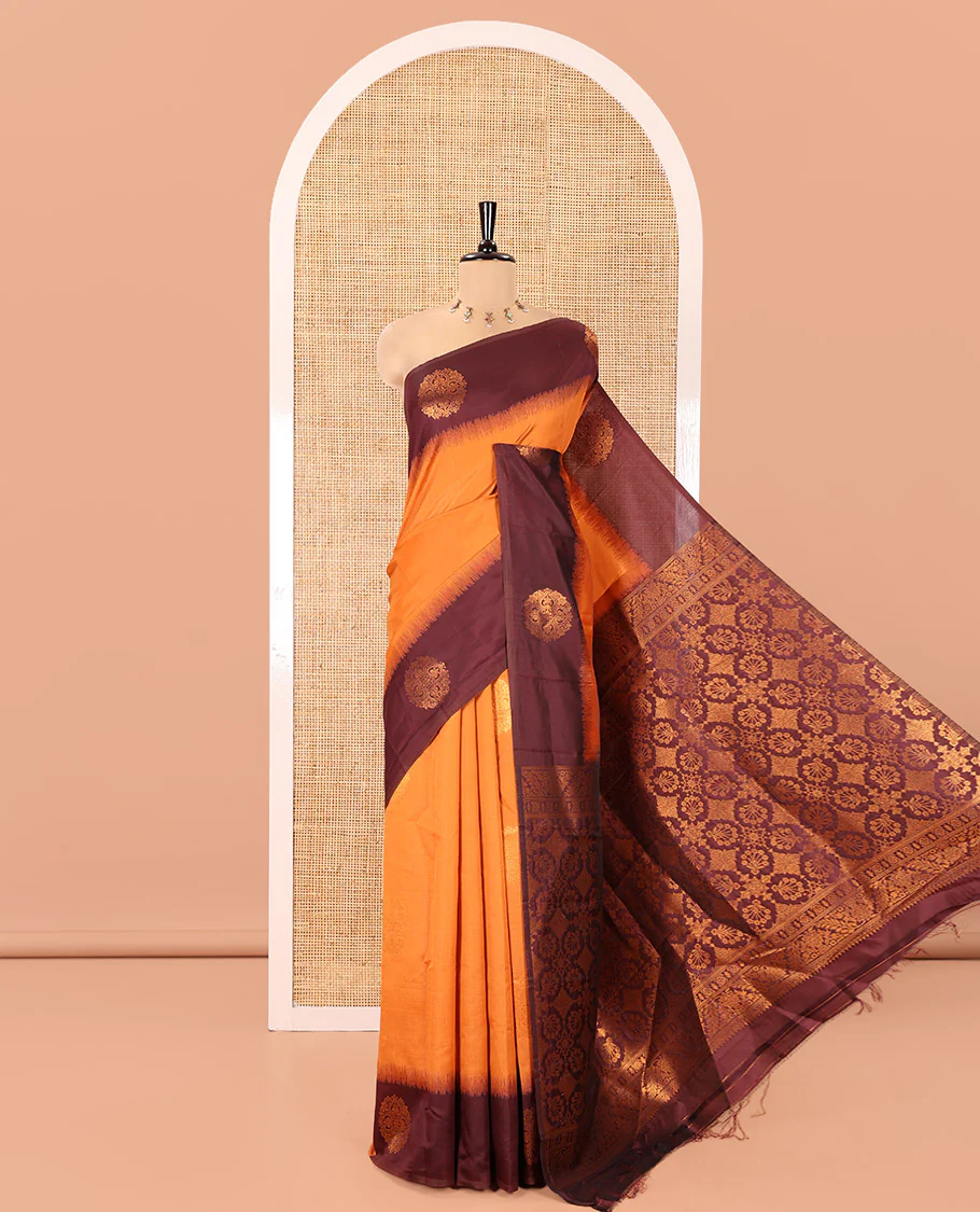 Rust Orange Kanchi Soft Silk Saree, Subtly Sparkled with Zari Buttas All Over Its Body, Complemented by a Contrast Chakram Motifs Border, an Intricately Designed Pallu, and Paired with a Contrast Blouse