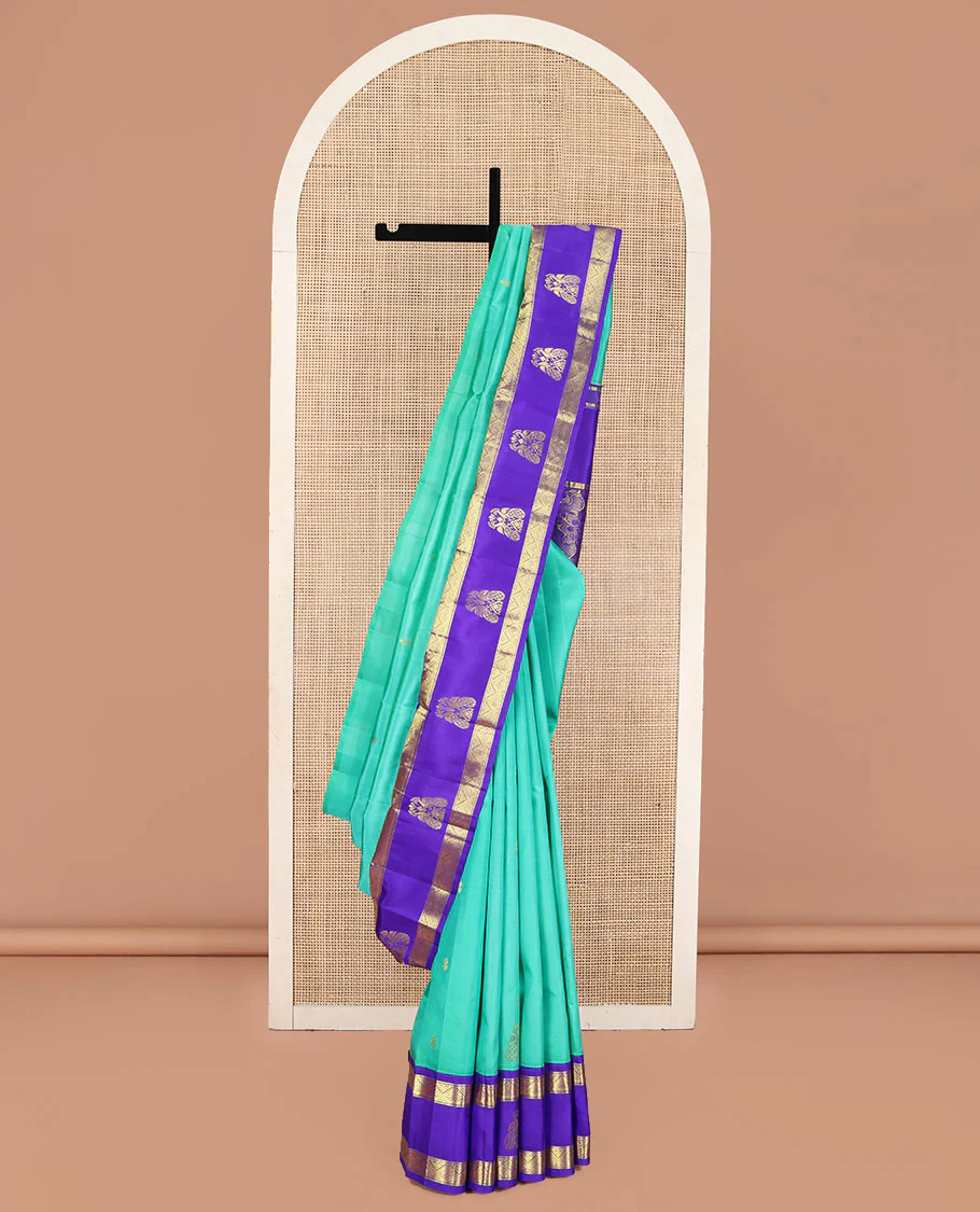 Turquoise Kanchipuram Silk Saree, Beautified with Zari Buttas on Its Body, Complemented by Contrast One-Sided Korvai Border of Diamond Designs, Pallu Steeped with Paisley and Floral Designs, and Comes Without a Blouse