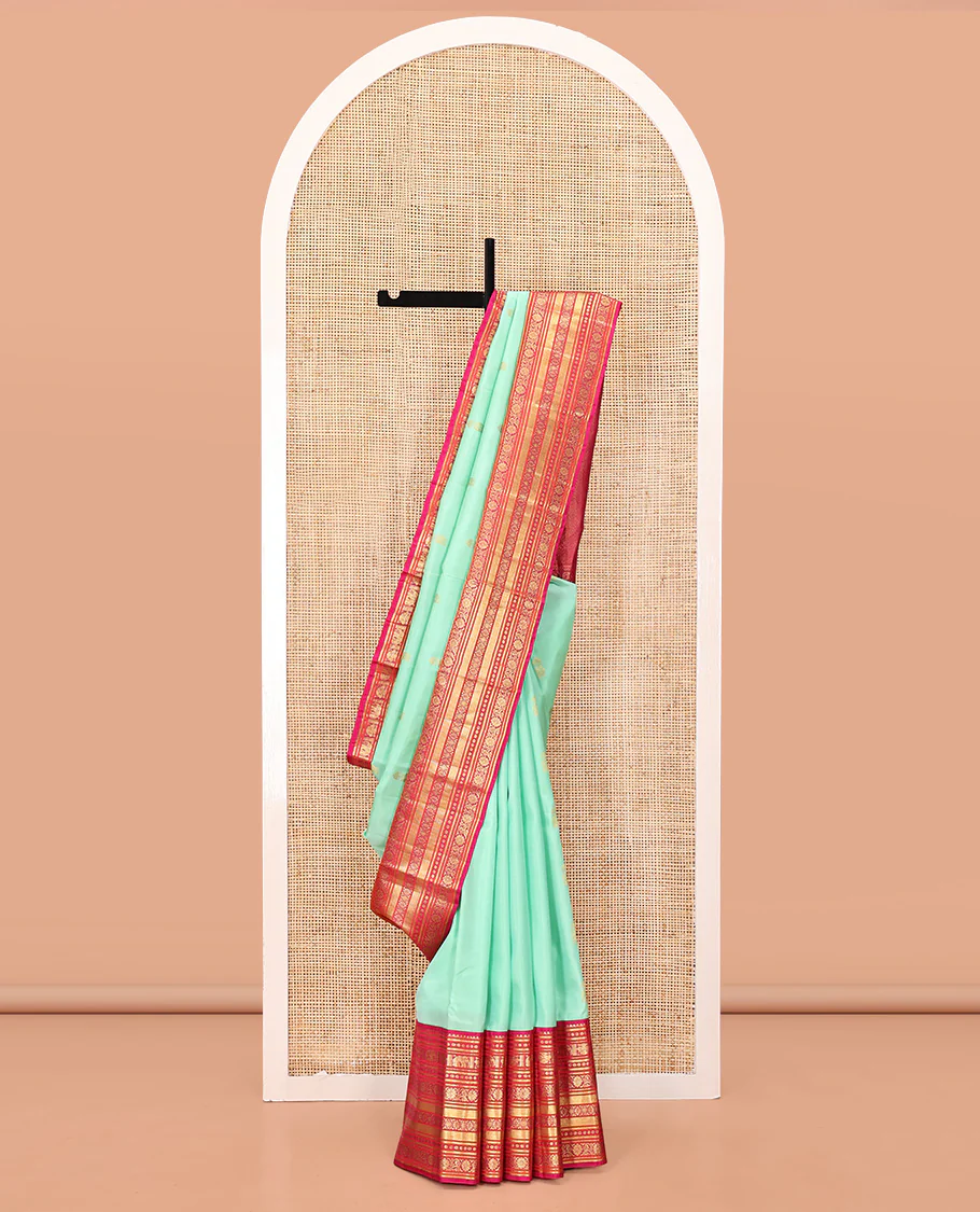 Turquoise Vasundhara Silk Saree, Embellished with Zari Buttas All Over Its Body, Complemented by a Contrast Border of Thilakam Mokku, Yaanai, Iruthalai Pakshi, and Kodi Visiry Designs, Grand Pallu, and Paired with a Contrast Blouse