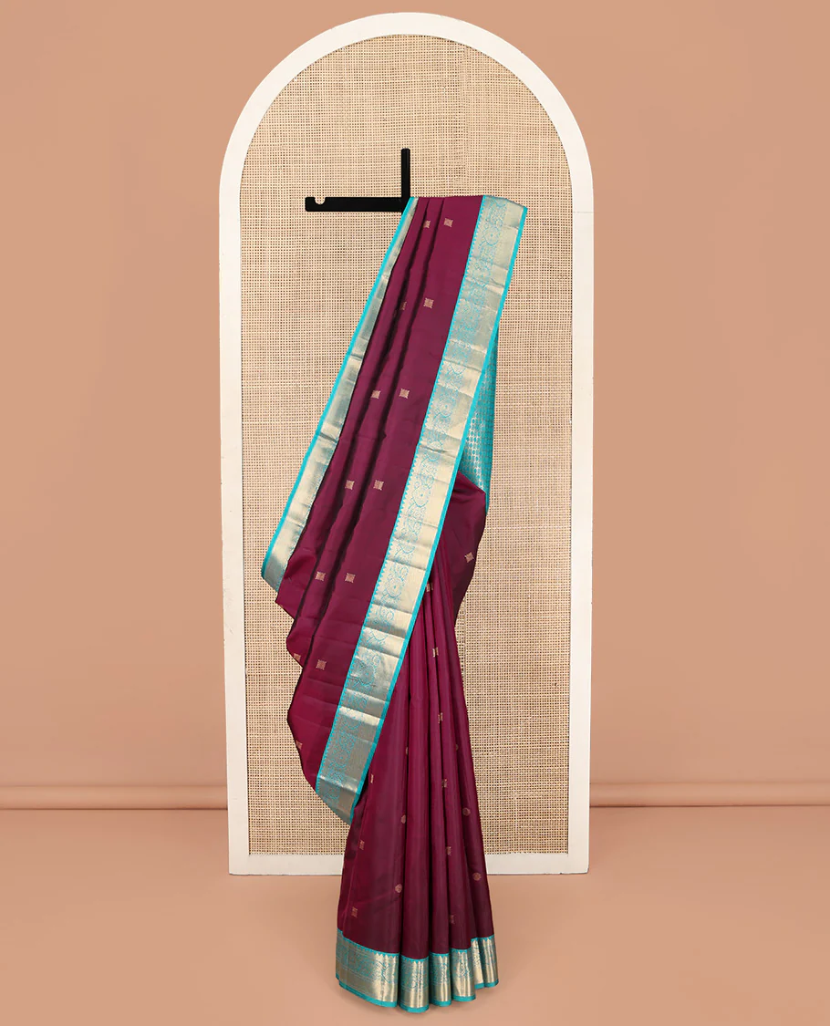 Wine Kanchipuram Silk Saree, Detailed with Zari Buttas on Its Body, Complemented by Contrast Border of Rekku, Muthu, Thilakam, and Mayil Kann Designs, Grandly Woven Pallu, and Paired with a Contrast Blouse