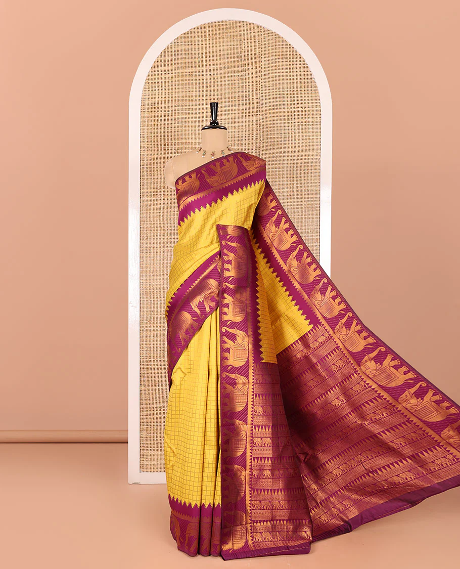 Yellow checked design litchi saree, contrast temple elephant motifs border, geometric patterned pallu, and a contrast jacquard blouse