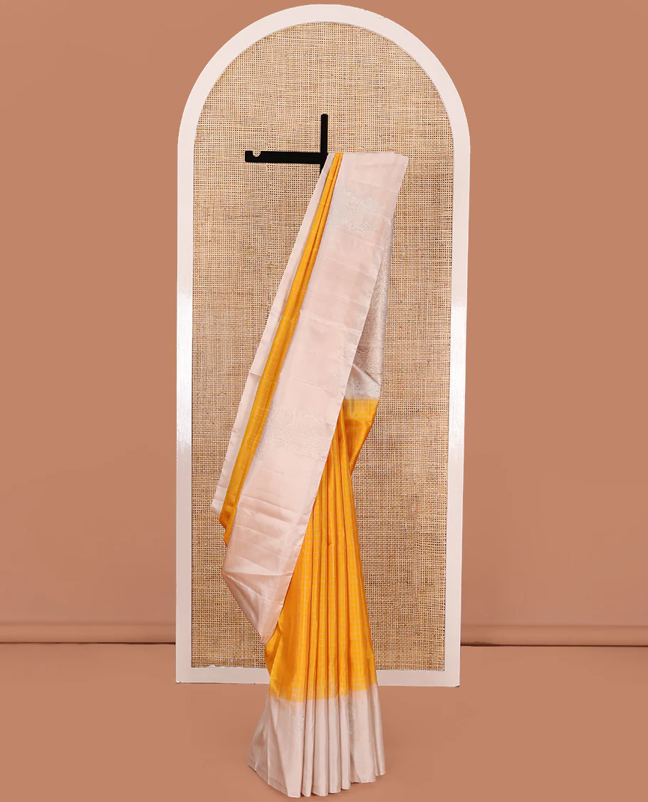 Yellow checked Kanchipuram silk saree, contrast border of zari buttas, and pallu of geometric patterns