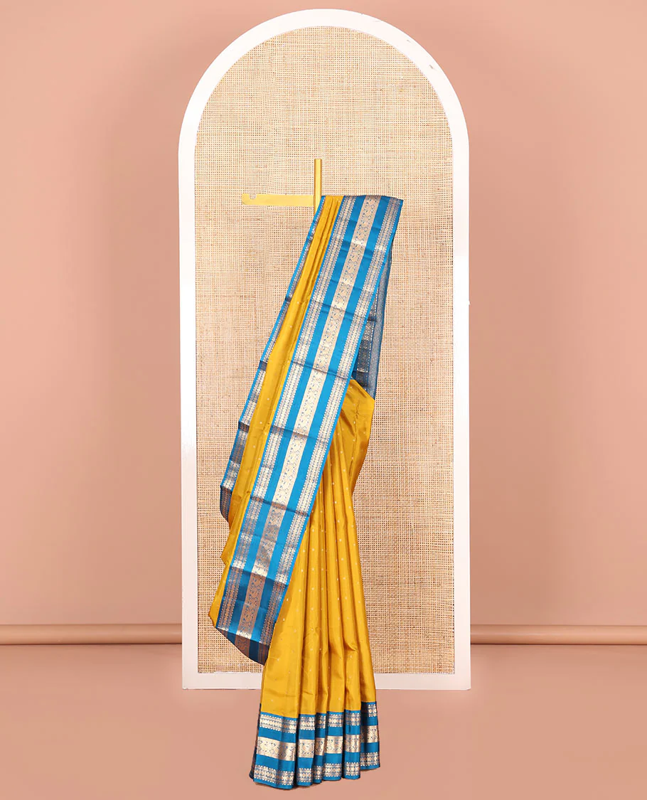 Yellow Vasundhara Silk Saree, Embellished with Zari Buttas All Over Its Body, Complemented by a Contrast Border of Rekku, Banaras, Rudraksham, Neli, and Mayil Designs, Grand Pallu of Geometric Patterns, and Paired with a Contrast Blouse