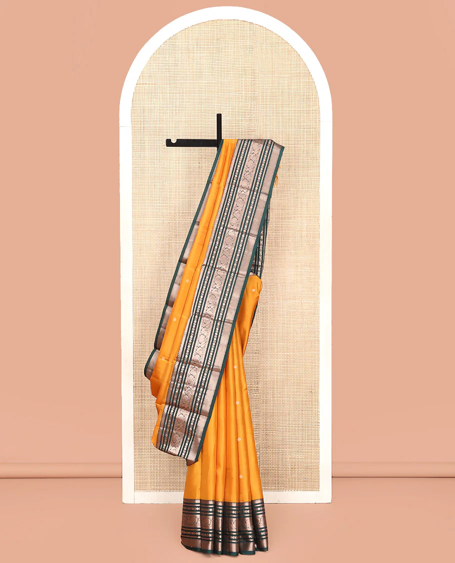 Yellow Vasundhara Silk Saree, Prettified with Zari Buttas All Over Its Body, Complemented by Contrast Border of Rekku, Muthu, Kathir, Poun, Mayil, and Mayil Kann Designs, Grand Jaal Pallu and Paired with a Contrast Blouse